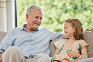 Conversation, smile and grandfather with child on a sofa bonding, relaxing and talking at home. Happy, family and senior man speaking to young girl kid on a couch in the living room at modern house.