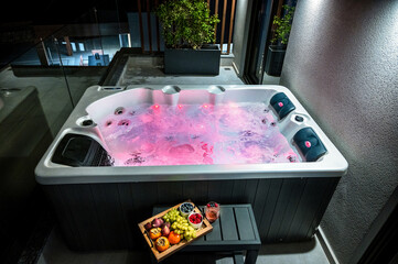 Relaxing Whirlpool Bath: Rose Water Light Ambiance with a Plate of Fresh Fruits Nearby. Perfect for conveying the luxurious and calming experience of a spa-like bath. 