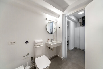 Contemporary White and Grey Bathroom Interior Design Concept: Minimalist, sleek, and stylish bathroom with white-themed elements, including sink, toilet bowl, walls, ceiling, and floors. 