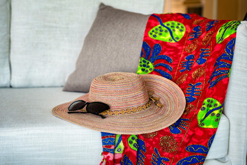 Summer Accessories Close-Up: A vibrant close-up photo featuring a stylish brimmed hat adorned with...