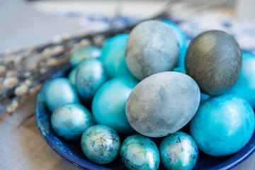 Easter still life background. Painted mother-of-pearl marble eggs and willow branches. Photo in...