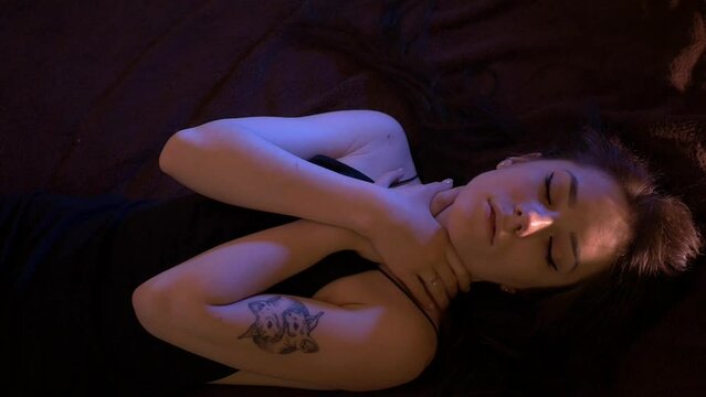 A beautiful half-naked woman lies on a bed. A depressed or infatuated state. Powerless tired girl on the bed.	
