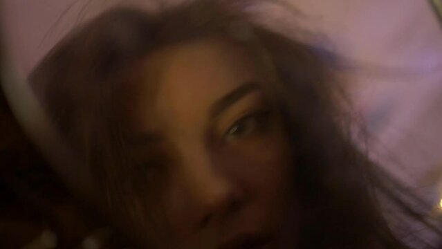 A beautiful half-naked woman looks into a broken mirror. The girl lies on a bed. A depressed state. Powerless tired girl on the bed.