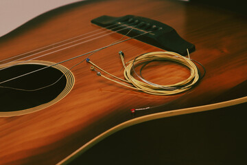 New acoustic guitar strings, pick on guitar. Strings for a classical guitar are prepared