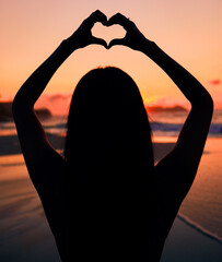 Woman, silhouette and sunset by sea with heart hands for love, care and kindness with sign, summer...