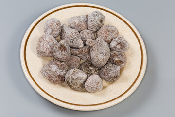 Dried figs on the saucer on a gray background