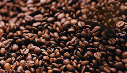 Macro fresh brown roasting coffee beans, warm light toning dark background