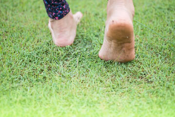 Image of bare feet of people walking on green grass