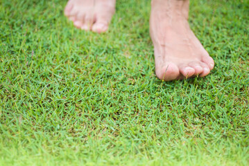 Image of bare feet of people walking on green grass
