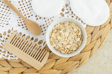 Small bowl with rolled oats for preparing homemade hair or face mask. Natural beauty treatment and spa recipe. Top view.
