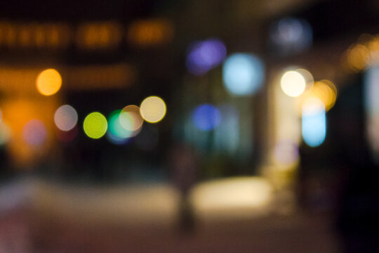 city street on winter holidays at night. blurred urban background with festive illumination. bokeh effect