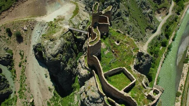 Erzurum Enguzek Castle is in ruins by the river and has been waiting for centuries Mountains clouds in the sky