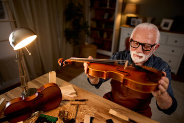 Senior violinmaker making violin instrument
