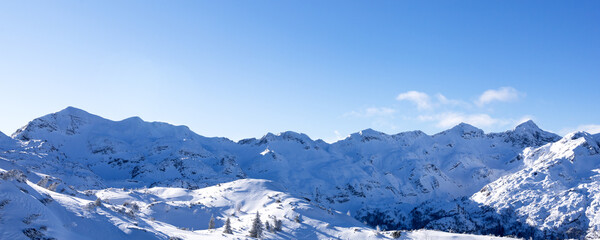 Panorama of snowy low mountains and hills on a sunny day in the foothills of the Alps
