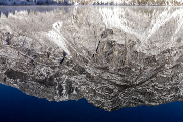 Reflection of the mountain and sky in winter in Lake Bohinj Slovenia
