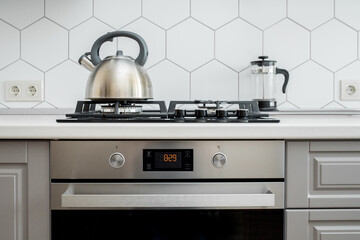 Built-in gas stove and oven in a modern kitchen with a kettle and teapot