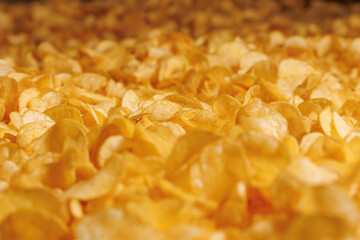 Fresh Crispy potato chips snack texture background with sun light, top view