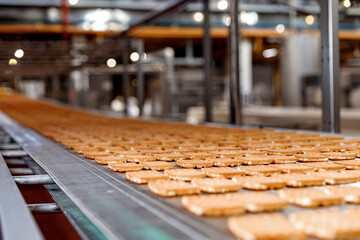 Closeup Belgian waffles on conveyor production line. Automatic bakery plant food factory - obrazy, fototapety, plakaty