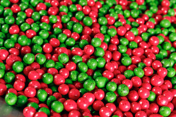 Fototapeta na wymiar Closeup red and green color dragee, chocolate covered nuts, sweet candy background