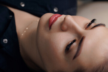 Obraz na płótnie Canvas Tattoo permanent makeup on red lips woman
