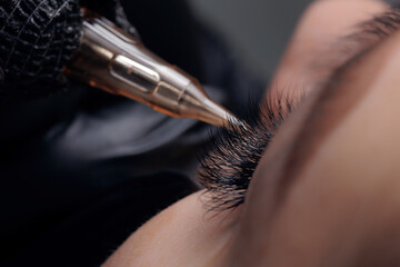 Procedure permanent makeup tattoo eyeliner on eye of beautiful woman