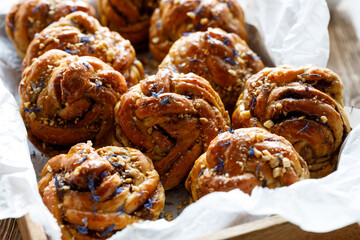 Sweet cardamom rolls sprinkled with chopped nuts and dried cornflower petals,  focus on the bun...