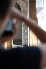 (Selective focus) Defocused girl in the foreground taking a photo at the Bahia Palace during a...
