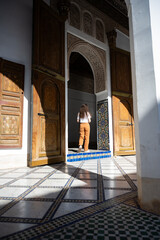 Stunning view of a girl visiting the Bahia Palace during a sunny day. The Bahia Palace in Marrakech is an impressive example of Moroccan architecture and design.
