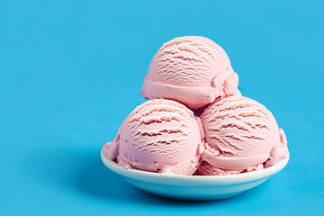 Scoops of pink ice cream in a plate on blue background