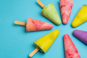 Colorful popsicles on blue background. Top view, flat lay