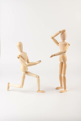 Wooden puppet holds a gold ring with a diamond. Marriage proposal.