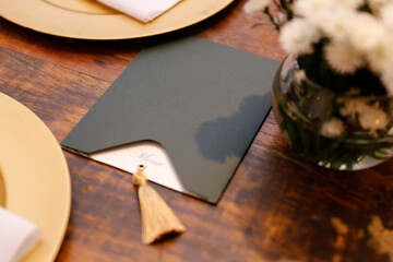 stylish menu in dark envelope on wooden table