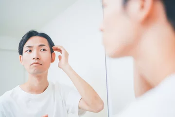 Fotobehang 洗面所でヘアセットをする男性 © HML