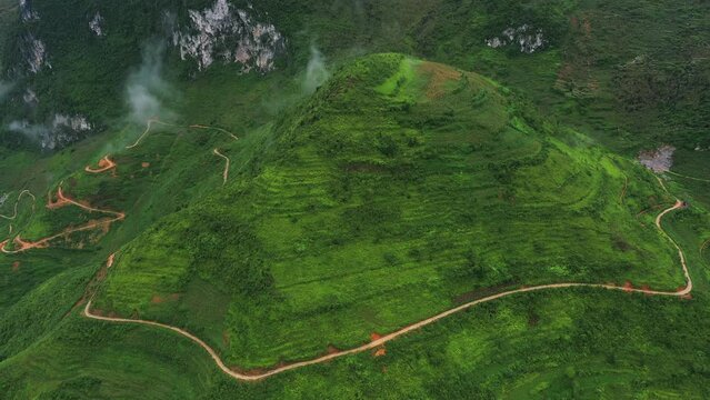 Drone of green mountains, landscape and highway for travel, adventure or holiday with background for eco tourism. Aerial view of green hill and road and nature to explore in Vietnam, Ma Pi Leng Pass