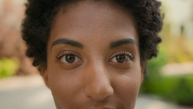 Extreme close up female face cropped African American ethnic girl woman young healthy lady close-up looking at camera eye problem eyes laser correction health medical spot on eyeball iris look macro - Powered by Adobe