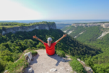 Mangup-Kale cave city, sunny day. A girl on the background of a mountain view from the ancient cave city of Mangup-Kale in the Republic of Crimea, Russia. Bakhchisarai.