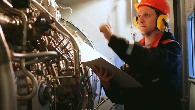 Industrial worker inspects turbine pre-engine start in industrial setting. Showcases industrial workers focus on safety, efficiency. Ideal for highlighting an industrial workers expertise.