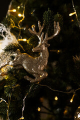 A New Year tree decorated with toys and gifts stands in the room. Christmas and New Year concept