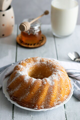 Homemade cake with powdered sugar and honey. On wood aphids. dessert.