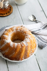 Homemade cake with powdered sugar and honey. On wood aphids. dessert.