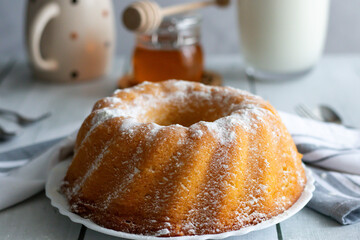 Homemade cake with powdered sugar and honey. On wood aphids. dessert.