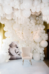 Arch decorated white balloons, angel wings, bears and chair for baptism. Photo area decoration...