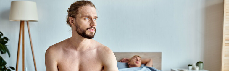 upset bearded man looking away while his love partner sleeping in bedroom, horizontal banner