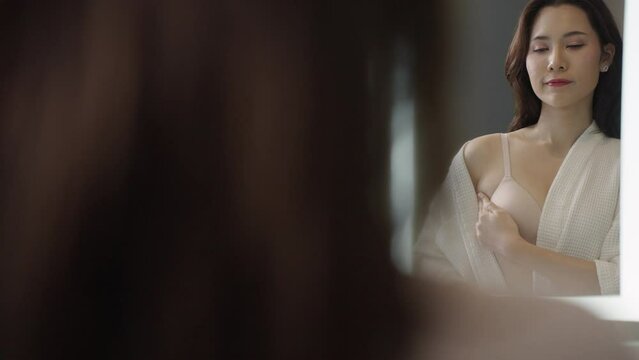 Breast Cancer, World cancer day. Asian woman examining, palpation for a lump or cancer in the breast.