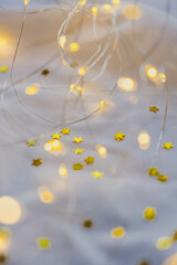 Christmas garland with golden stars on white fabric, soft focus background