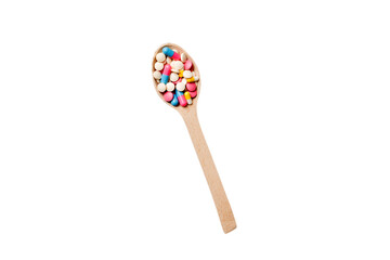 Vitamin capsules in a wooden spoon on a colored background. Pills served as a healthy meal. Drugs, pharmacy, medicine or medical healthycare concept