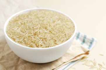 Raw basmati rice in a white bowl on a light background. Concept of Water-Conserving Products. Saving water. Dietary product. Healthy Eating. Horizontal orientation.