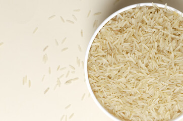 Raw basmati rice in a white bowl on a light background. Concept of Water-Conserving Products. Saving water. Dietary product. Healthy Eating. Horizontal orientation. Top view. Copy space.