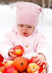 Happy smiling baby with apple in winter day