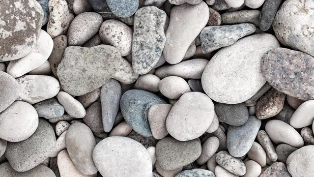 Pebbles, large oval beach sea stones, top view, rotating, turning, close-up macro, top view